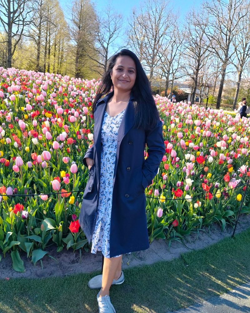 Manali standing in front of a field of tulips